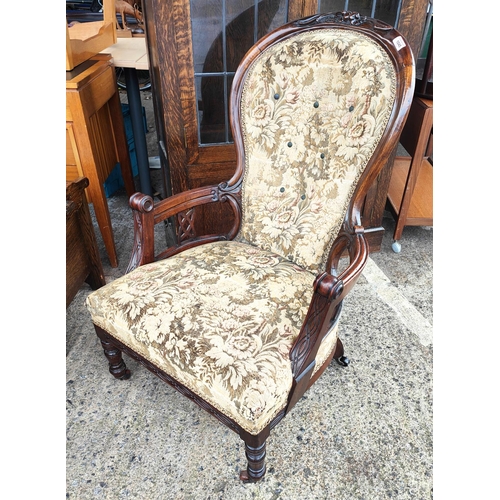 1045 - A Victorian carved mahogany arm chair with spoon back tapestry upholstery knurled legs 