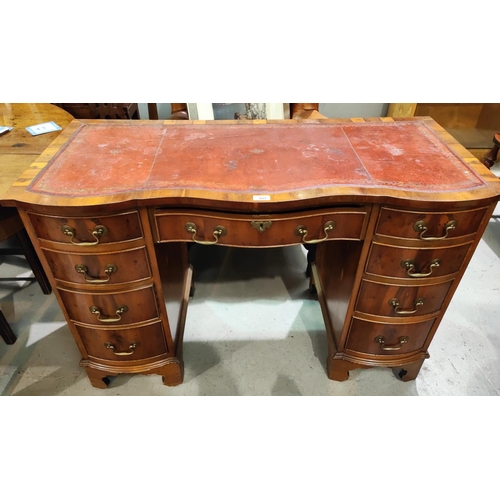 927 - A reproduction pedestal kneehole desk in yew wood, with inset red leather top, frieze drawer and 8 p... 