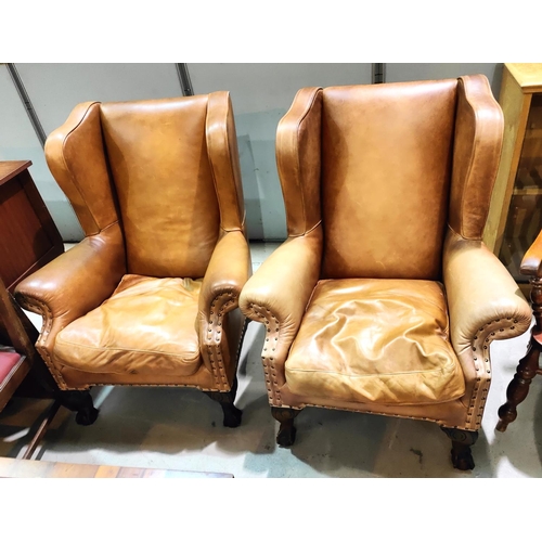 988 - A pair of wingback armchairs in tan hide