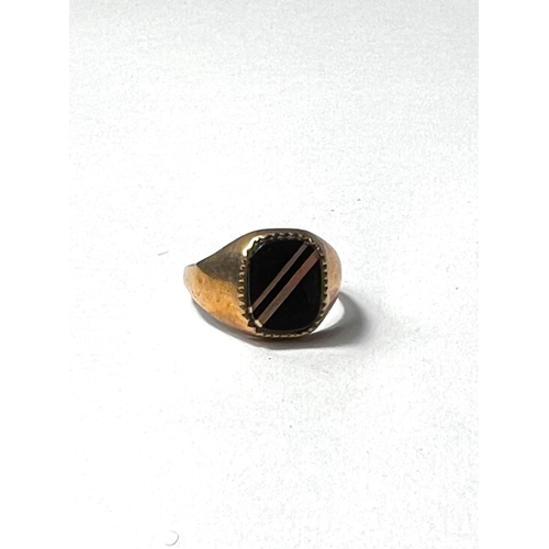 606 - A 9ct gold gents signet ring set with a black stone, 3.2gms gross