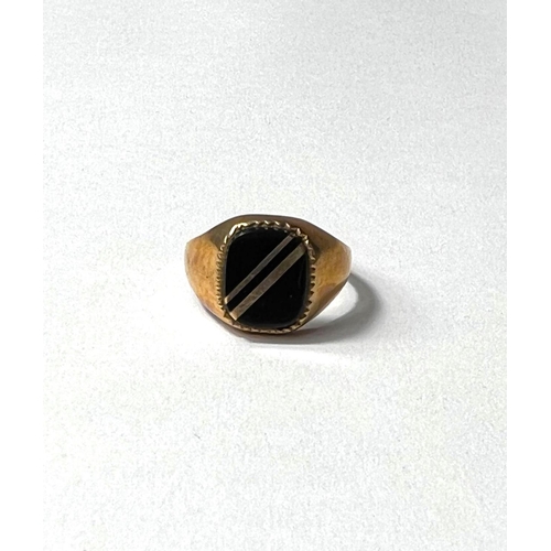 606 - A 9ct gold gents signet ring set with a black stone, 3.2gms gross