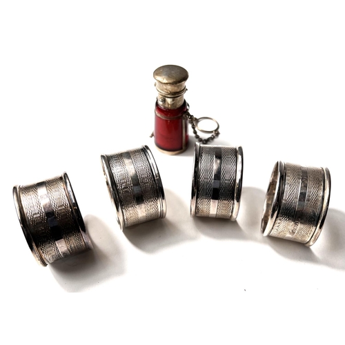 622 - A hallmarked silver set of engine turned napkin rings, Birmingham 1945, 2oz; a silver mounted whisky... 