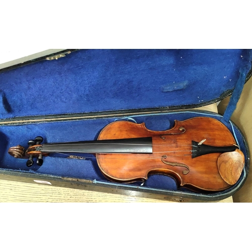 340 - A late 19th early 20th century full sized violin with two piece back wooden chin rest, in wooden fit... 