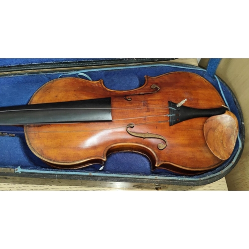 340 - A late 19th early 20th century full sized violin with two piece back wooden chin rest, in wooden fit... 