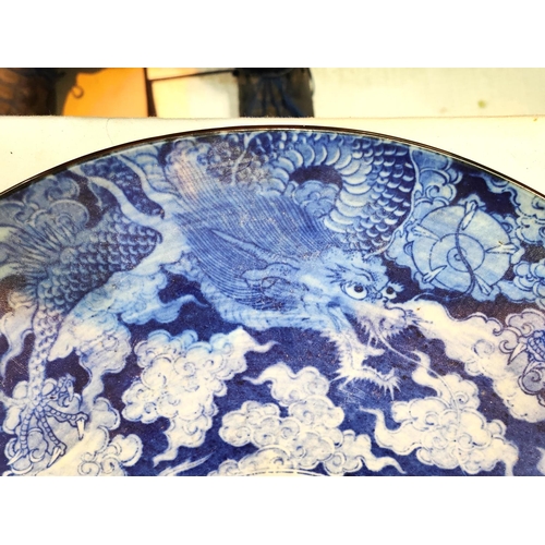 357 - A Chinese blue and white charger decorated with five clawed dragon circling mythical bird, 47cm