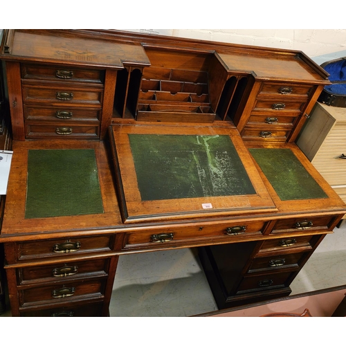 990 - An Edwardian mahogany kneehole desk with raised back, 8 small drawers and letter rack, slope front w... 