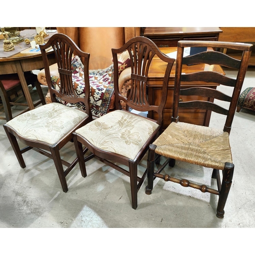 1029 - A country made ladder back rush seat chair and two mahogany Chippendale style dining chairs with flo... 