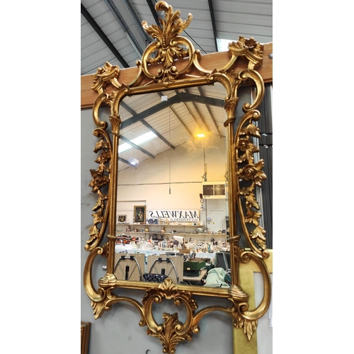 927A - A Georgian style wall mirror in ornate gilt frame