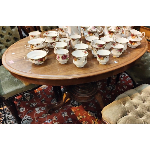 957 - An oval tilt top mahogany supper table with base, 121cm.