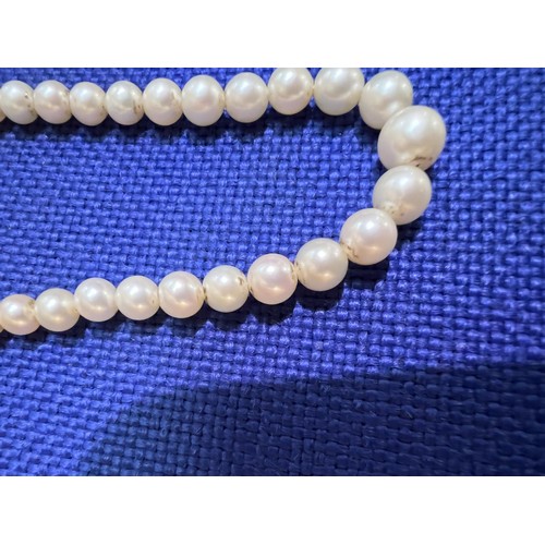 679 - A single strand graduated pearl necklace, with Art Deco style white metal gem set clasp, stamped '9c... 