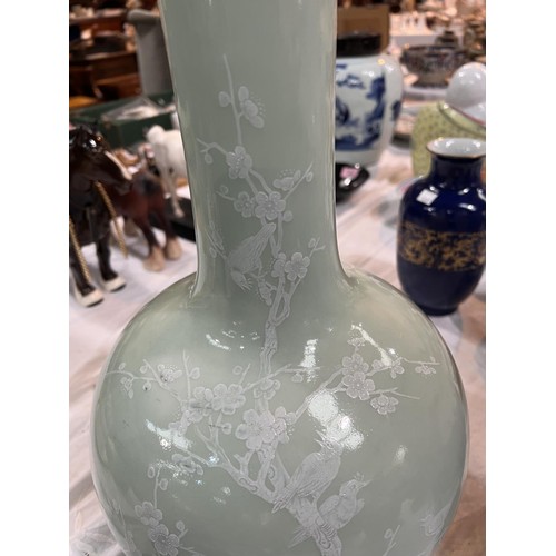 449A - A Chinese celadon bottle vase decorated in white with birds on branches etc seal mark to base, heigh... 