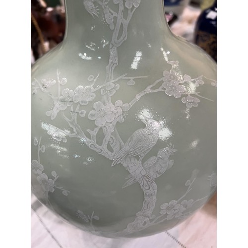 449A - A Chinese celadon bottle vase decorated in white with birds on branches etc seal mark to base, heigh... 