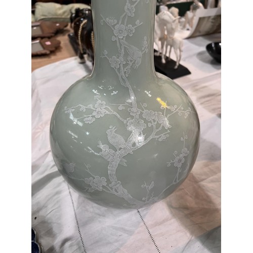 449A - A Chinese celadon bottle vase decorated in white with birds on branches etc seal mark to base, heigh... 