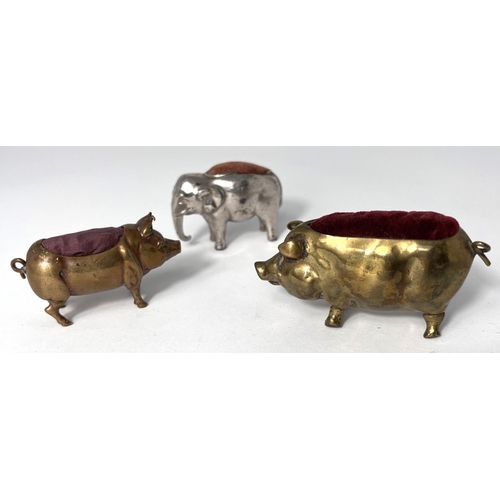 109A - Two brass pig pin cushions and a similar silver plated elephant pin cushion