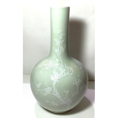 414 - A Chinese celadon bottle vase decorated in white with birds on branches etc seal mark to base, heigh... 