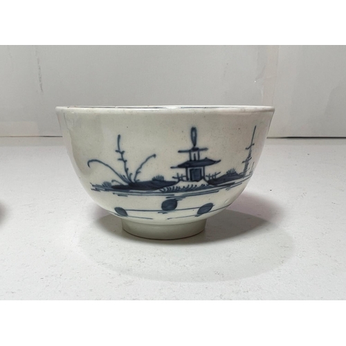 562 - A first period Worcester tea bowl and saucer in blue & white decorated with pagodas in landscape... 