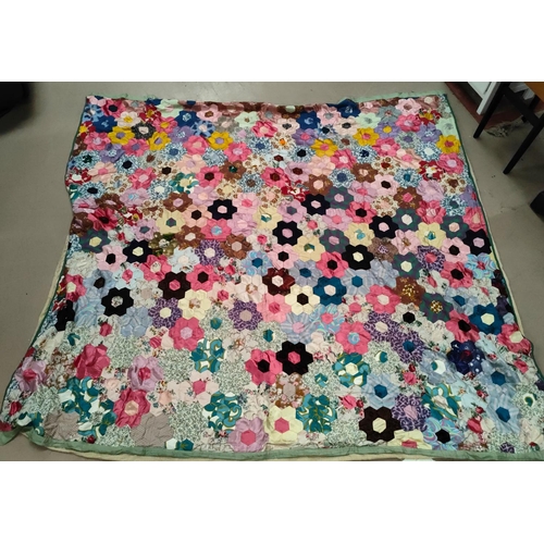 62 - A large vintage patchwork quilt made up of hexagonal pieces in a floral shape, 215x200 cm 