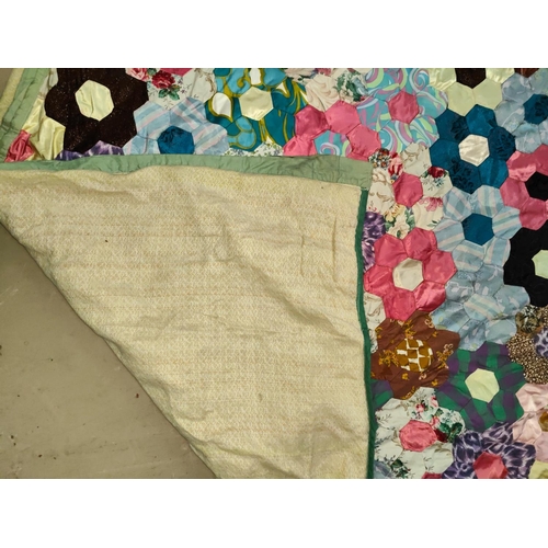 62 - A large vintage patchwork quilt made up of hexagonal pieces in a floral shape, 215x200 cm 