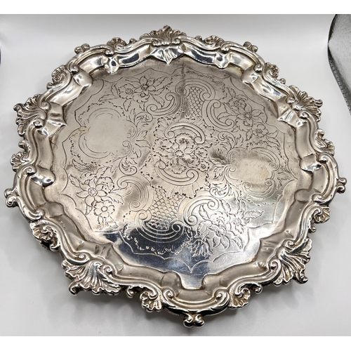 648 - A circular Georgian hallmarked silver salver with scroll and acanthus border and chased centre, on 3... 