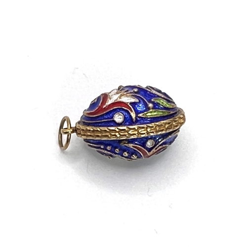 660F - An enamel egg shaped pendant blue ground with floral decoration