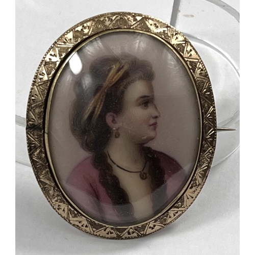 708 - A miniature bust portrait on porcelain brooch of a young lady in 18th century dress in yellow metal ... 