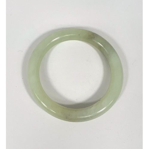 718 - A Chinese jade coloured hard stone bangle