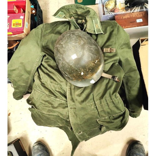 388 - An M1 WWII style American composition helmet with strapping inside, a large green military style ove... 