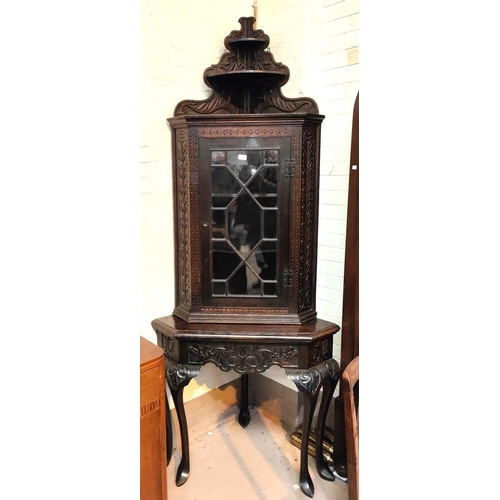 946 - A large Victorian full height carved oak corner cupboard on stand with astragal glazed door, shelves... 