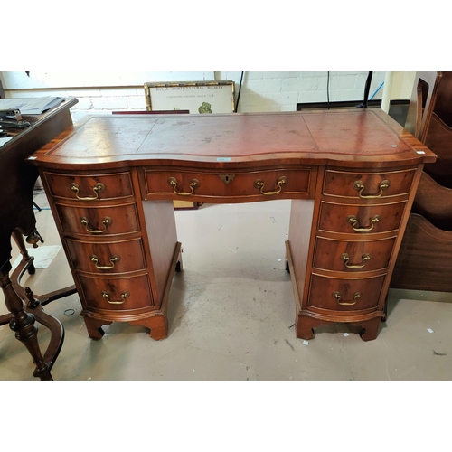 859 - A reproduction pedestal kneehole desk in yew wood, with inset red leather top, frieze drawer and 8 p... 