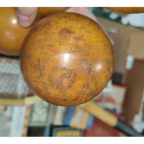 135 - A pair of wooden dumb bells, a vintage tennis racket, a selection of vintage boxed games.