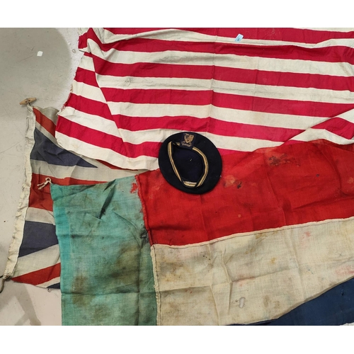 367 - A selection of vintage flags and a woollen cap with a badge