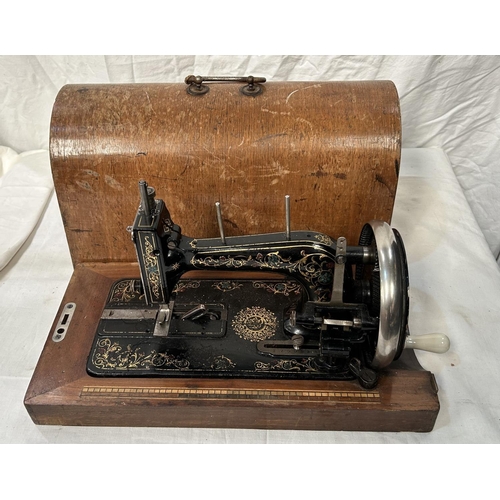 55 - A vintage cased Jappaned metal sewing machine