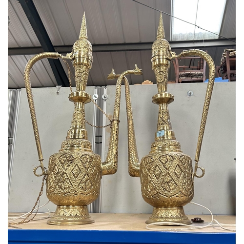 56 - A pair of large brass middle eastern lamps in the form of Jugs, with pierced decoration to the bodie... 