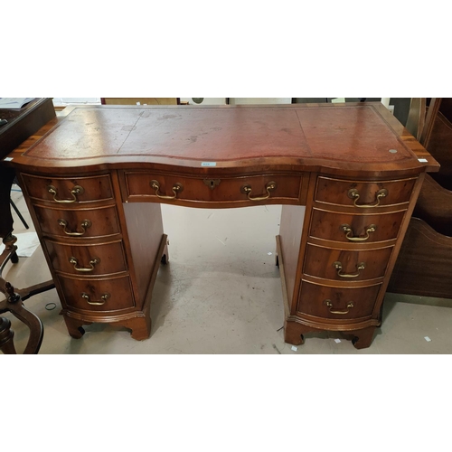 859 - A reproduction pedestal kneehole desk in yew wood, with inset red leather top, frieze drawer and 8 p... 