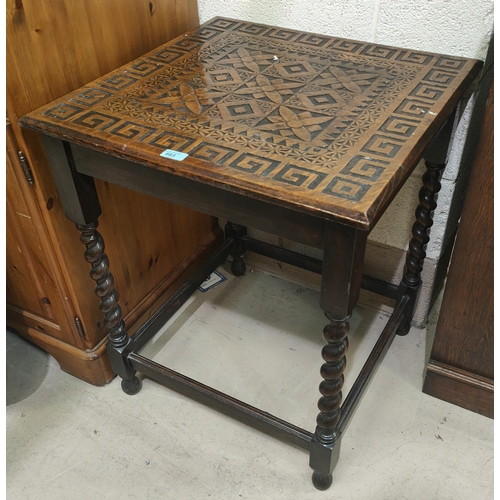 883 - An early 20th century oak occasional table with geometric carving to the square top, on barley twist... 