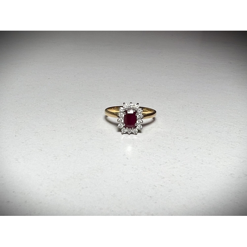 624A - A 18ct hallmarked gold ring set with a central emerald cut ruby surrounded by 14 diamonds.