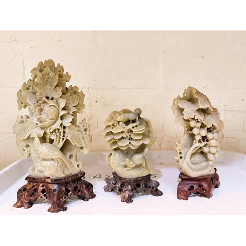 394A - 3 light green soapstone carvings on brown bases, Peony, fruiting vine and squirrel heights 17cm, 13c... 