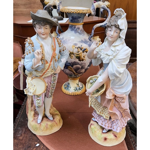 493A - A Majolica style 2 handled vase and a pair of continental figures in 18th century dress (chipped)