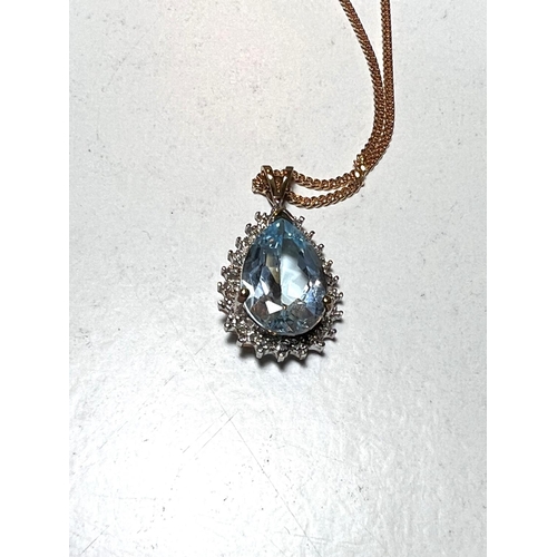 624B - An 9ct hallmarked gold pendant set with a teardrop shaped aquamarine coloured stone surrounded by sm... 