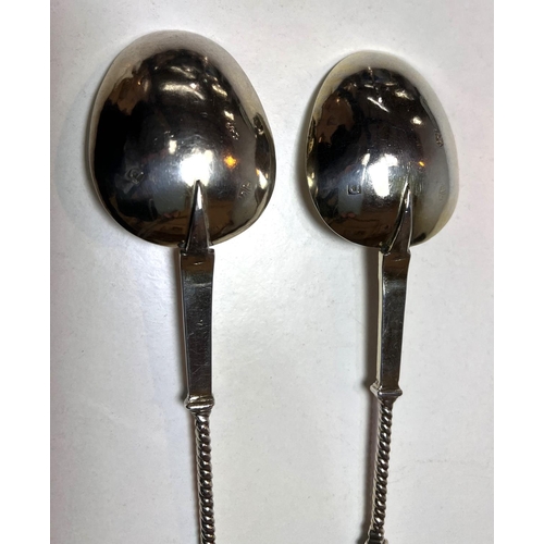 622D - A pair of continental white metal apostle top anointing spoons with monogrammed and gilded bowls.&nb... 