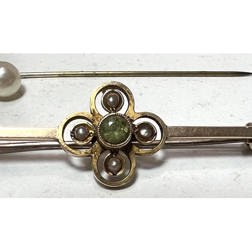 705 - An Edwardian 9 carat gold bar brooch set peridot and seed pearls and a stick pin