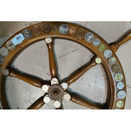 148 - An ornamental ships wheel decorated with 59 coins from around the world, 47 cm diameter; a similar f... 