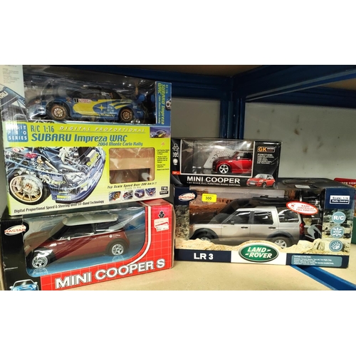 300 - A boxed Rastar radio controlled Land Rover 1:14 scale, two boxed remote controlled Mini Coopers (no ... 