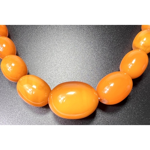 644 - An early/mid 20th century amber necklace formed from graduating oval 'butterscotch' beads, largest b... 