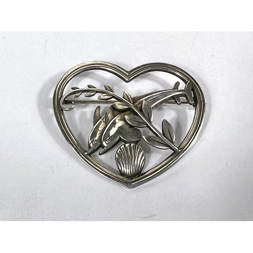 662 - Georg Jensen:  a heart shaped openwork brooch with a pair of dolphins and strand above shell, s... 