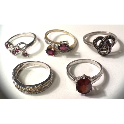 679 - Five modern silver dress rings:  garnet and white zircon crossover; oval garnet; marcasite knot... 