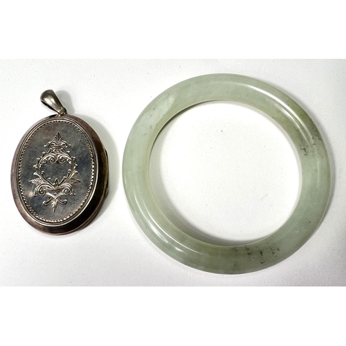 722 - A late 19th century locket with incised decoration to the front and back; a Chinese jade coloured ha... 