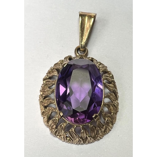 758 - A pendant set with a large amethyst coloured stone, the yellow metal surround stamped 333 