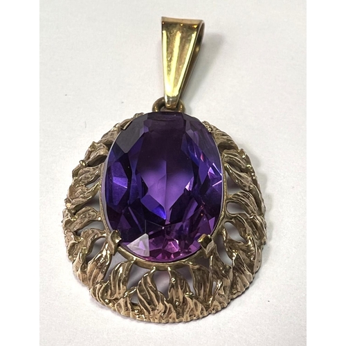 758 - A pendant set with a large amethyst coloured stone, the yellow metal surround stamped 333 