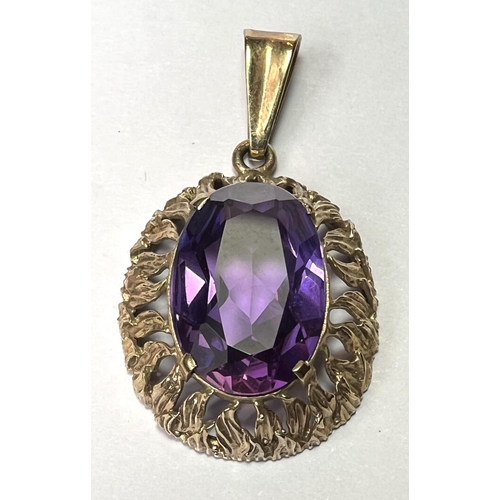 758 - A pendant set with a large amethyst coloured stone, the yellow metal surround stamped 333 